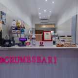Una volta entrati notiamo immediatamente la somiglianza tra Crumbs e un originale punto vendita della catena Crumbl. Proprio come nei locali statunitensi, al centro si trova il classico bancone bianco dietro cui � possibile assistere alla preparazione dei dolci